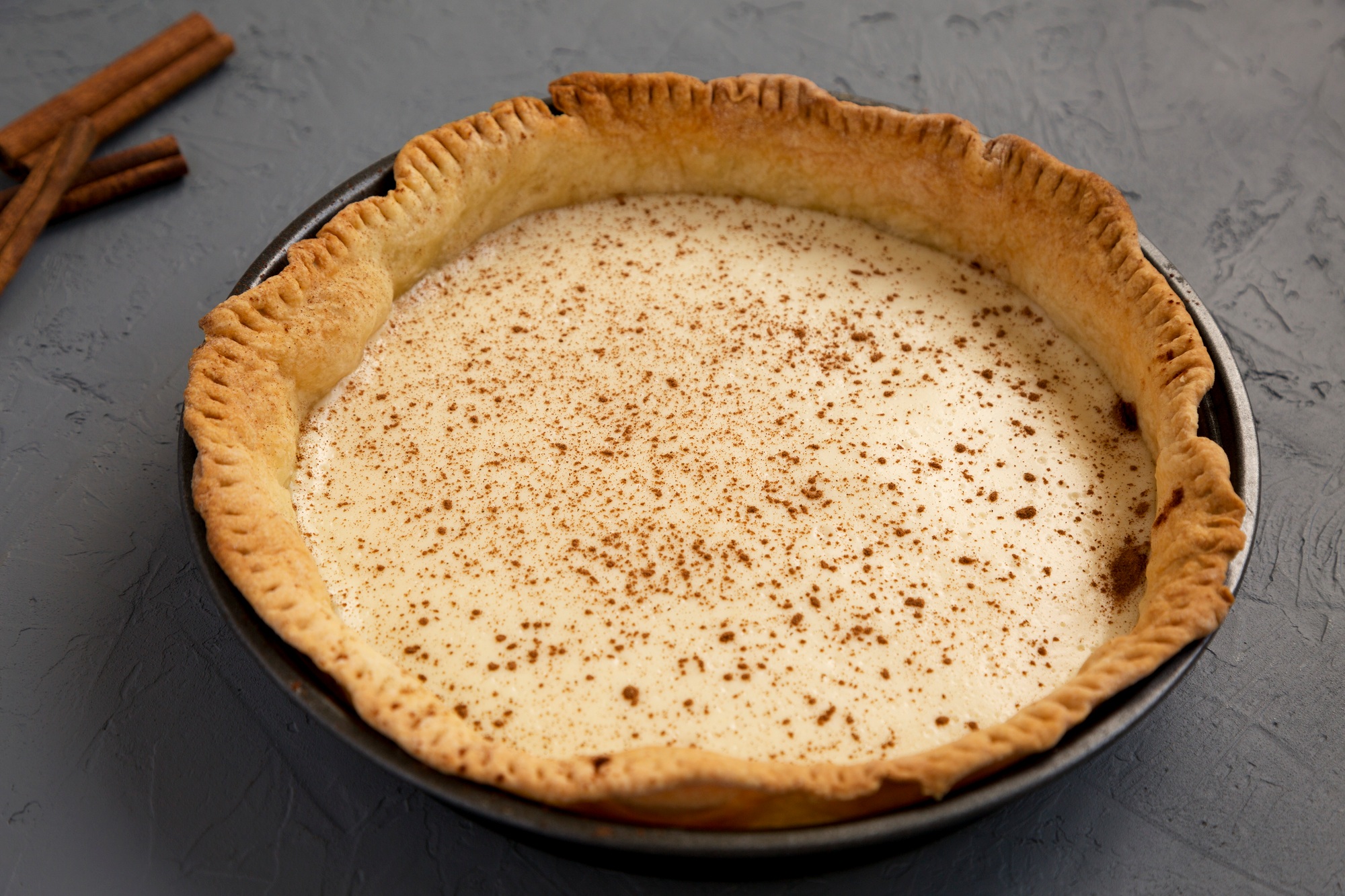 Homemade Sugar Cream Pie on a gray surface, side view.